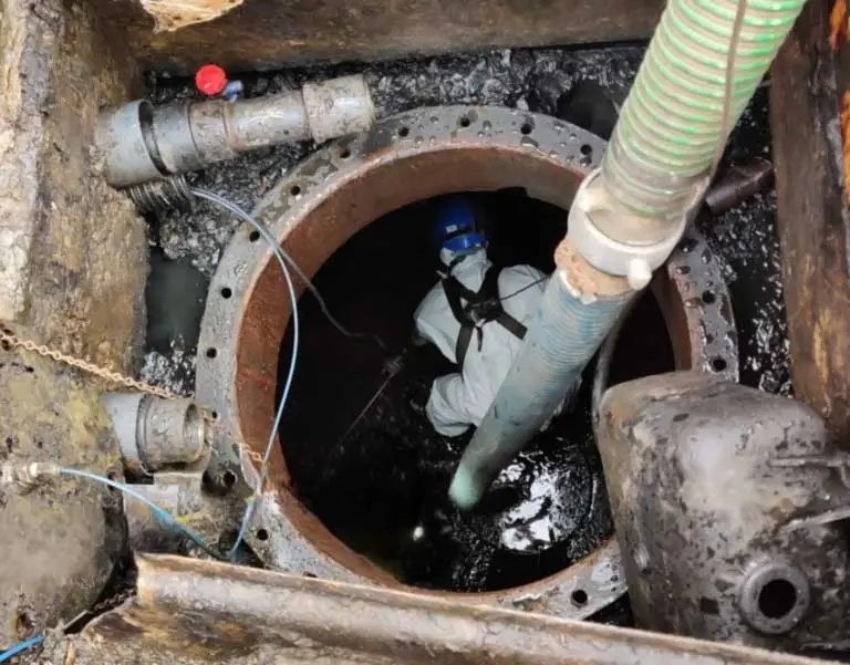 A KpH Environmental Operative performing tank cleaning service in a confined space